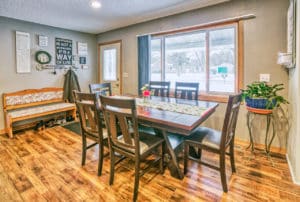 Remodeled dining area with large windows and wood floors.