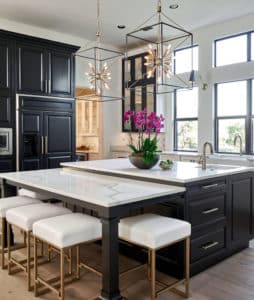 Remodeled kitchen with black cabinet island and white marble countertops 