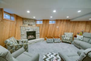 Basement remodel with recessed lighting and built-in fireplace.