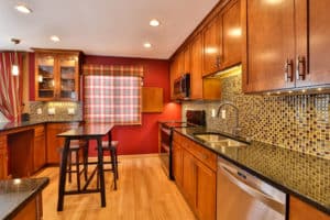 Remodeled kitchen with custom tile backsplash and wooden cabinets.
