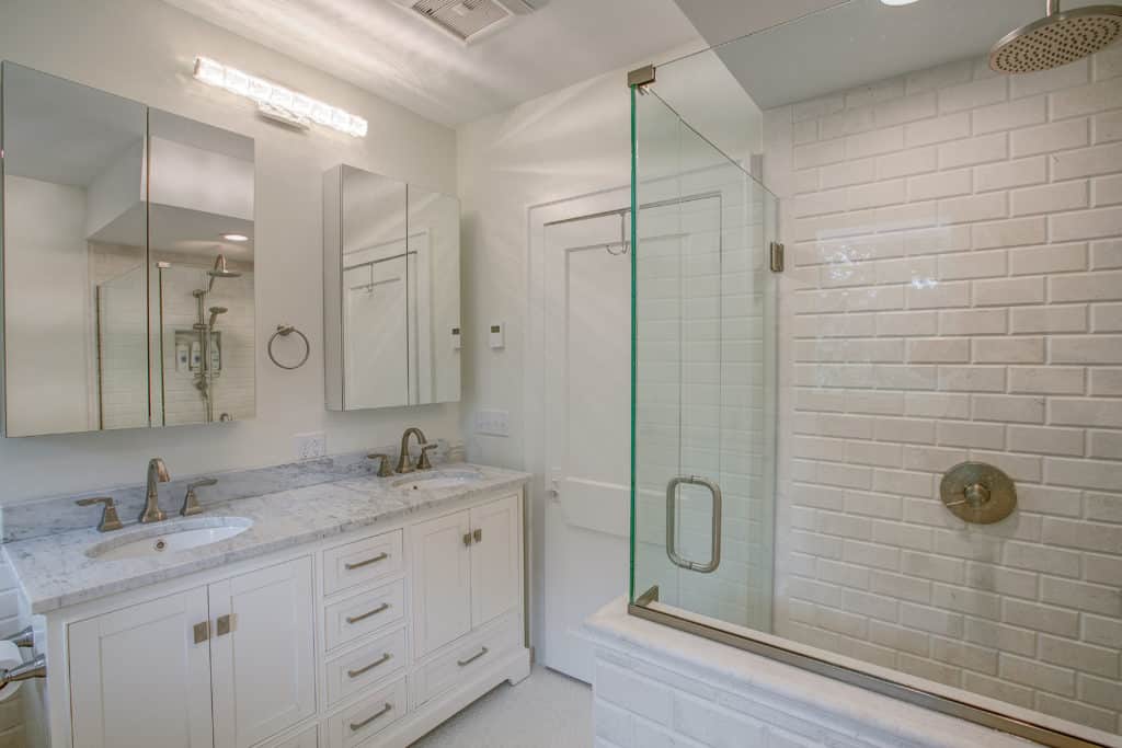 Bathroom with walk-in shower and white cabinets
