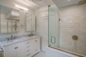 Bathroom with walk-in shower and white cabinets