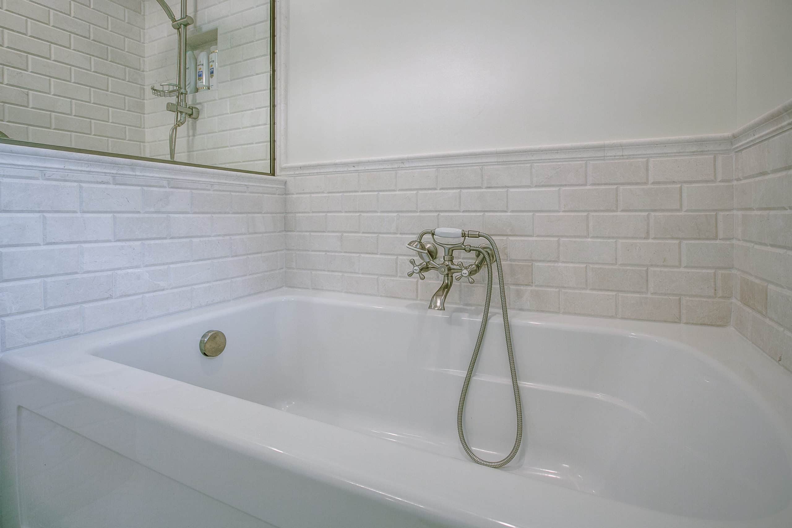 Whit bathtub with tile backsplash