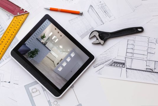 home remodel plans with wrench and tablet